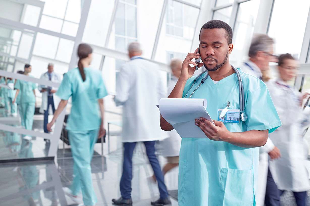 Physcician on phone in busy open area